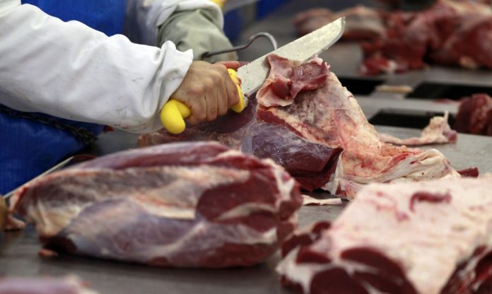 #Pracegover Foto: Na imagem há um açougueiro cortando carne