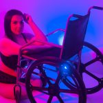 #Pracegover Foto: na imagem há uma linda mulher cadeirante no chão de lingerie, com um braço na cadeira de rodas, com o cotovelo esquerdo na cadeira e a mão esquerda na cabeça