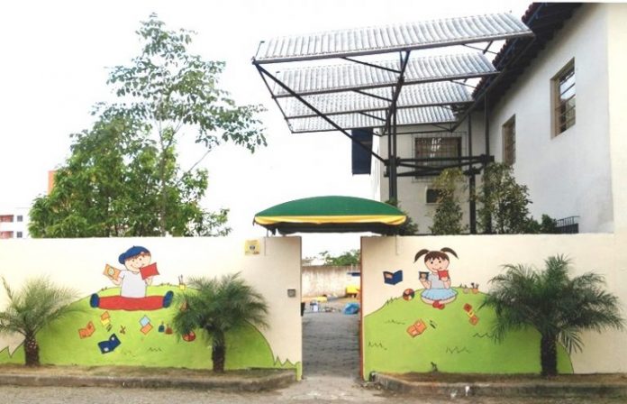 #Pracegover Foto: Na imagem há o prédio da instituição Joanna de Angelis, um muro pintado e com figuras de crianças e em frente ao muro há três plantas