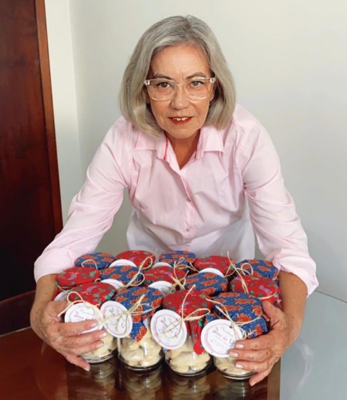 #Pracegover Foto: na imagem há uma mulher com potes de biscoitos