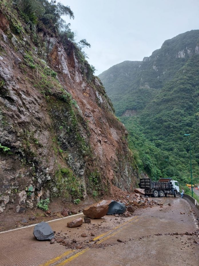 #Pracegover Foto: na imagem há um caminhão e pedras e barro na rodovia
