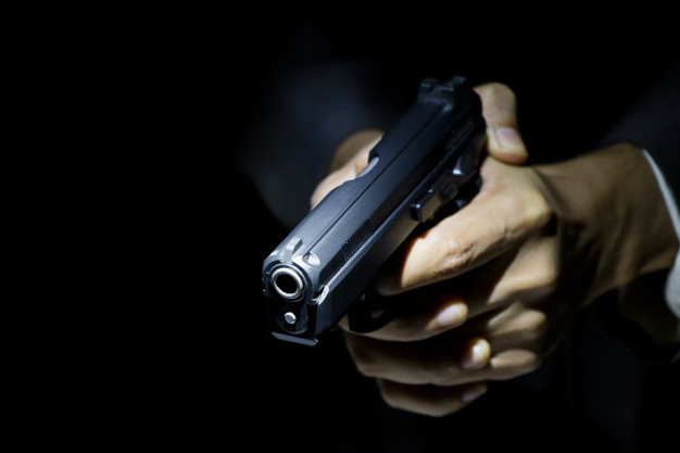 #Pracegover Foto: na imagem há uma arma de fogo e duas mãos