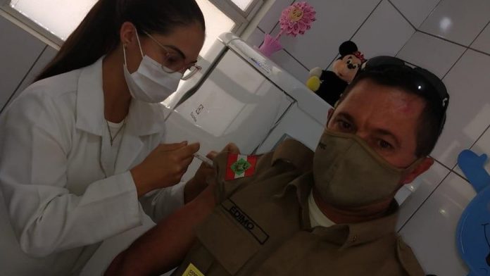#pracegover Na foto, Sargento Édimo Antônio Garcia aparece recebendo a vacina