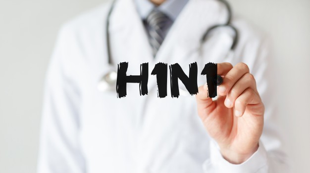 #Pracegover Na foto, médico aparece escrevendo a palavra H1N1