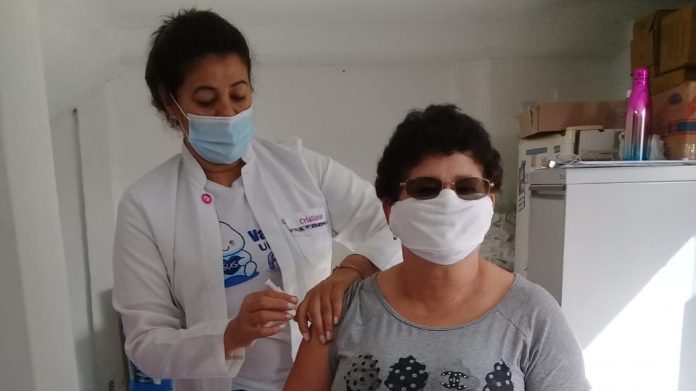 #Pracegover Na foto, profissional da saúde vacinando uma pesssoa