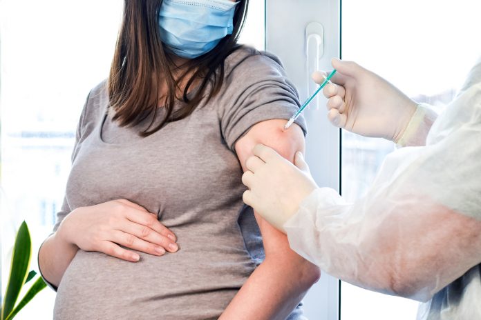 #Pracegover Foto: na imagem há uma mulher grávida recebendo uma vacina