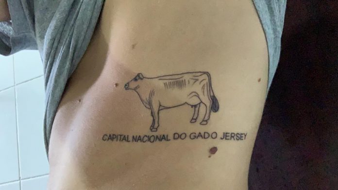 #Pracegover Foto: na imagem um jovem fez uma tatuagem de uma vaquinha em sua costela
