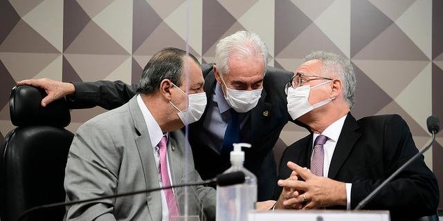 #Pracegover foto: na imagem há 3 homens de terno e com máscara, microfone e um frasco de álcool em gel