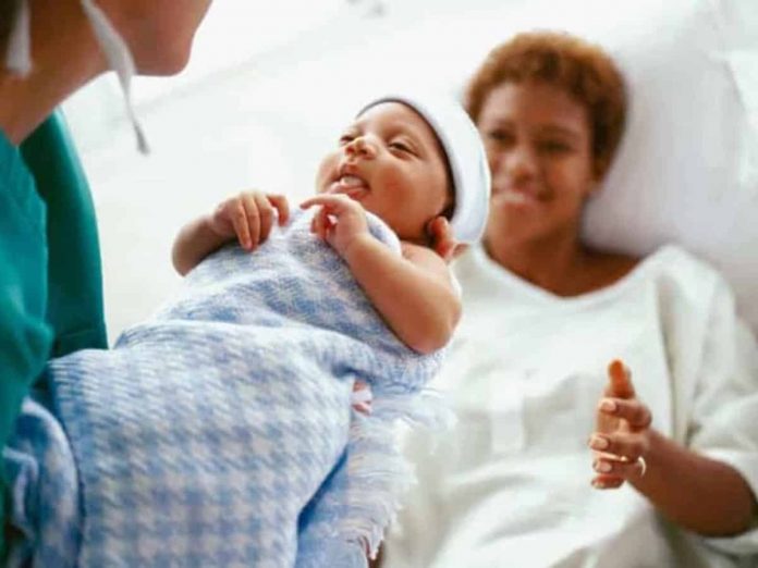 #Pracegover foto na imagem há um bebê, uma enfermeira e a mãe da criança