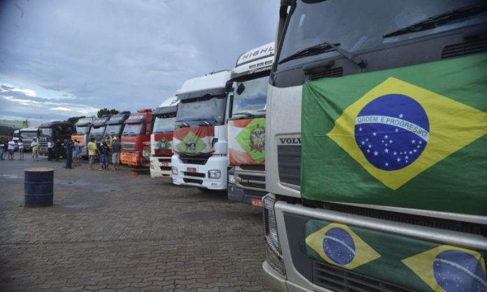 #Pracegover foto: na imagem há vários caminhões e um deles com a bandeira do Brasil e outro com a de SC