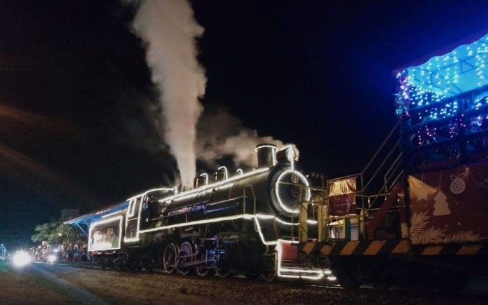 #Pracegover foto: na imagem há um trem com luzes e saindo vapor