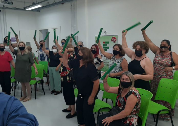 #Pracegover Foto: na imagem há mulheres comemorando com diplomas nas mãos e cadeiras verdes