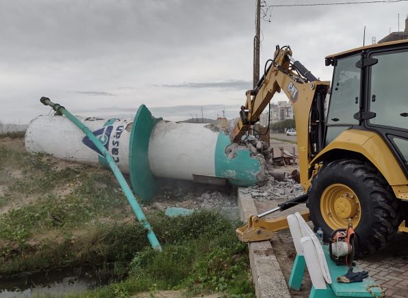 #PraCegoVer Na foto, um trator faz a demolição de uma estrutura de concreto
