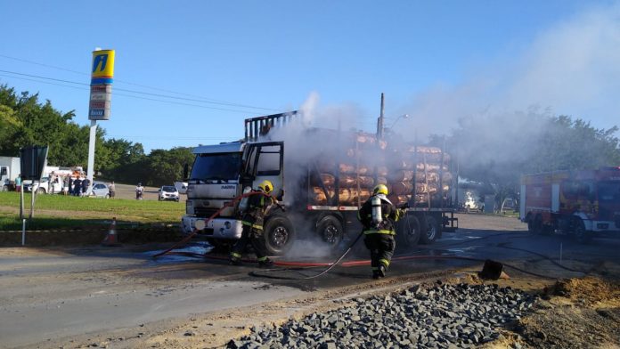 #PraCegoVer Na foto, dois bombeiros apagam o incêndio em um caminhão