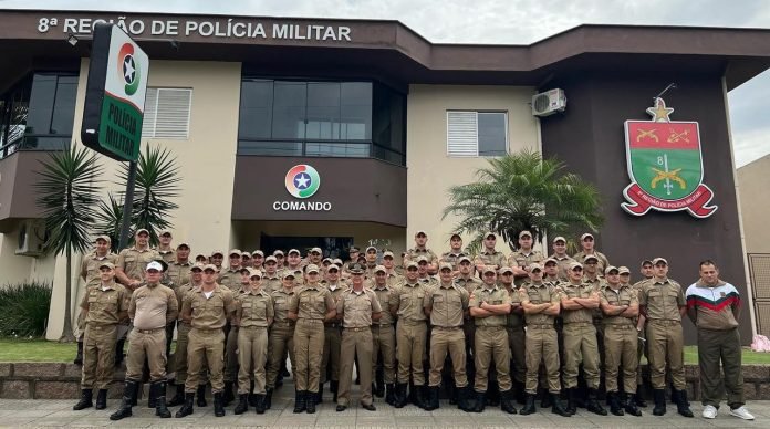 #PraCegoVer Na foto, policiais militares alinhados em frente a um prédio público