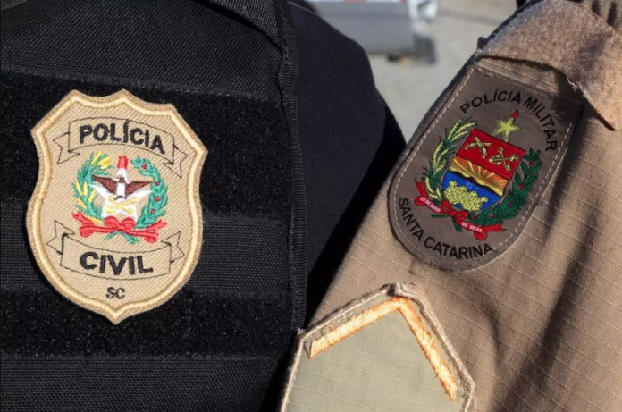 #PraCegoVer Na foto, o emblema da Polícia Civil e da Polícia Militar de Santa Catarina