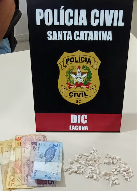 droga DIC Laguna #PraCegoVer Na foto, uma placa com emblema da Polícia Civil de Santa Catarina, com dinheiro e drogas na frente