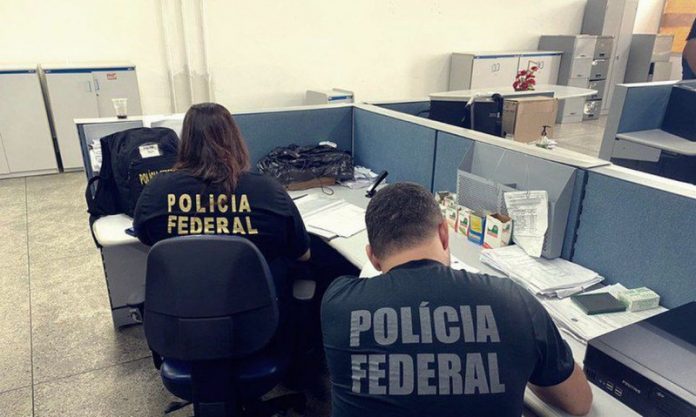 #PraCegoVer Na foto, dois policiais federais trabalham em um escritório