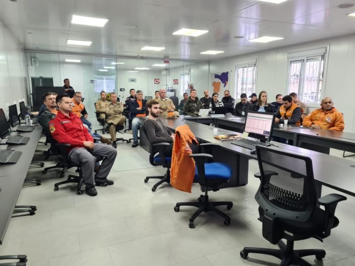 Defesa Civil #PraCegoVer Na foto, um grupo de pessoas discutem medidas preventivas por conta da chuva