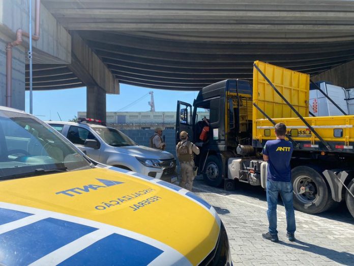 #ParaTodosVerem Na foto, policiais militares e um agente da Agência Nacional de Transportes Terrestres fiscalizam um caminhão de cargas