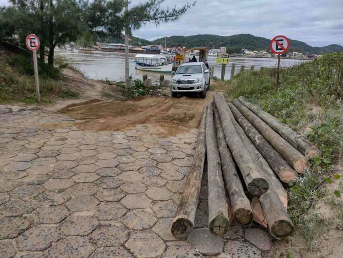 #PraCegoVer Na foto, Materiais depositado ao lado do acesso ao bote que faz a travessia do Canal da Barra, em Laguna