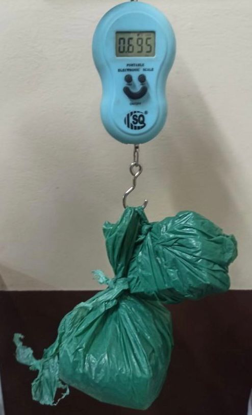 #ParaTodosVerem Na foto, uma sacola verde com maconha dentro, pendurada em uma balança