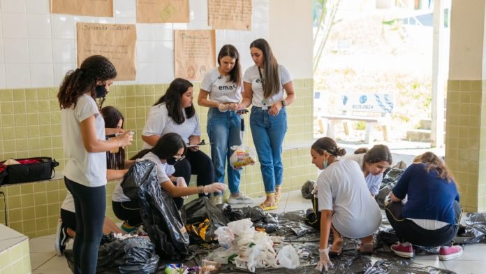 EMA #PraCegoVer Na foto, membros do projeto EMA ensinam um grupo de alunos como separar o lixo e fazer adubo orgânico