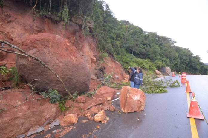 Garopaba #PraCegoVer Na foto, Agentes da Defesa Civil vistoriam encostas de morros que deslizaram sobre uma estrada