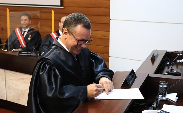 #PraCegoVer Na foto, o juiz Narbal Fileti assina o termo de posse como desembargador do TRT-SC