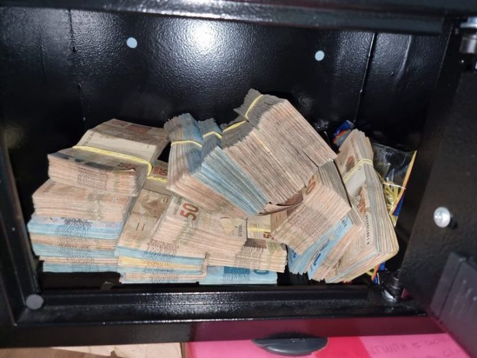 #PraCegoVer Na foto, um cofre com vários maços de dinheiro
