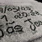 #ParaTodosVerem Na foto, o parabrisa de um carro coberto por um camada fina de neve, onde alguém escreveu 17/05/22, -1, 20:22, São Joaquim/SC