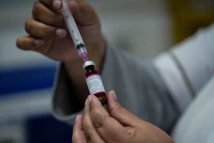 #ParaTodosVerem Na foto, uma enfermeira coloca uma dose de vacina contra o sarampo em uma seringa