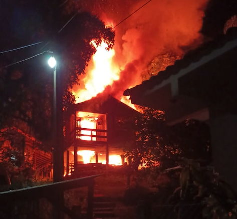 #ParaTodosVerem Na foto, uma casa de madeira, de dois pisos, completamente tomada pelo fogo