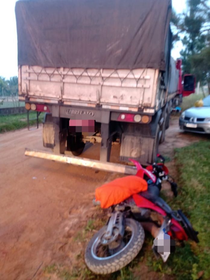 #ParaTodosVerem Na foto, uma motocicleta caída atrás de um caminhão em uma rua de chão batido