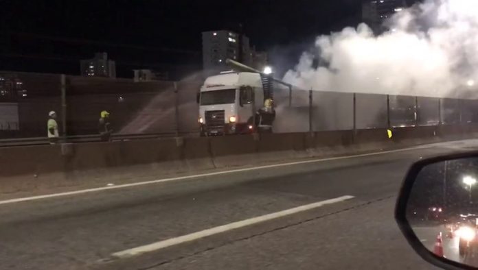 #ParaTodosVerem Na foto e no vídeo, homens trabalham para apagar um incêndio em uma caminhão após a colisão de uma motocicleta