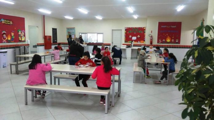 #ParaTodosVerem Na foto, crianças comem merenda em uma escola