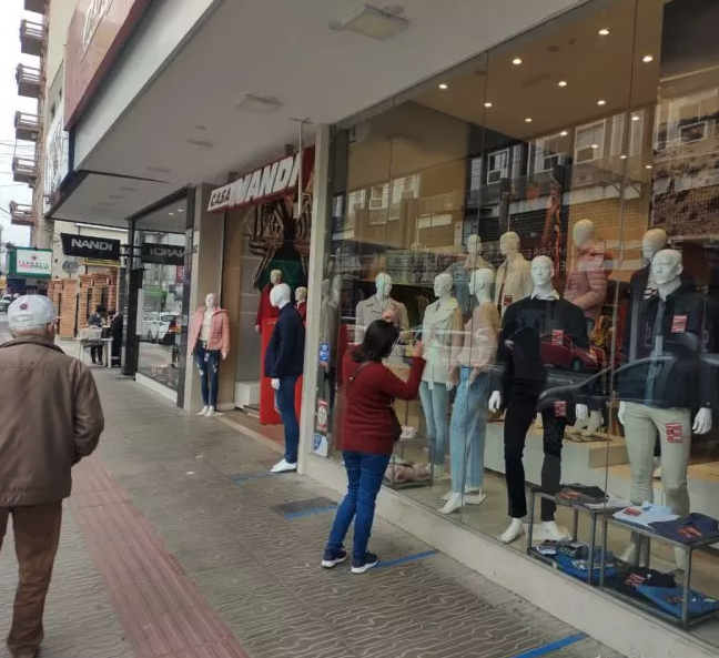 #ParaTodosVerem Na foto, uma mulher olha produtos em uma vitrine