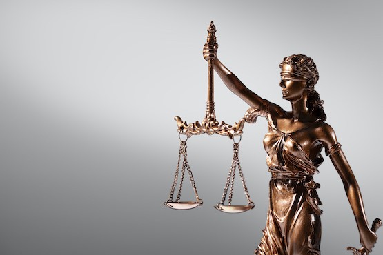 Imagem do símbolo da Justiça: Mulher vendada com balança na mão direita. Estátua em dourado.